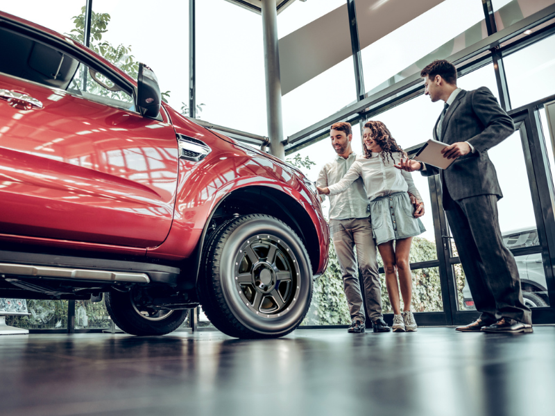 People standing with Salesmen looking at a truck on display